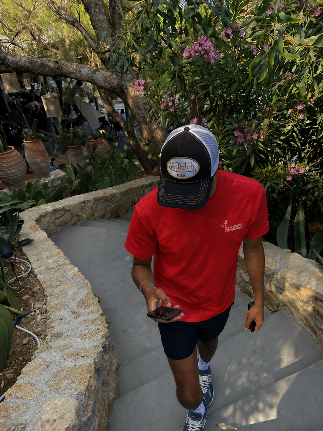 Mann im mediterranen Garten trägt Hadix Angel T-Shirt in rot. normaler schnitt, Hadix essentials, Basic tshirt
